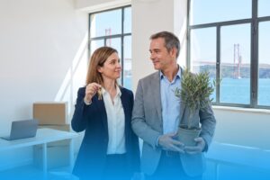 Founder holding the new keys and co-founder with an olive tree in their new office in Lisbon, the Tagus and the 25 de Abril Bridge in the window